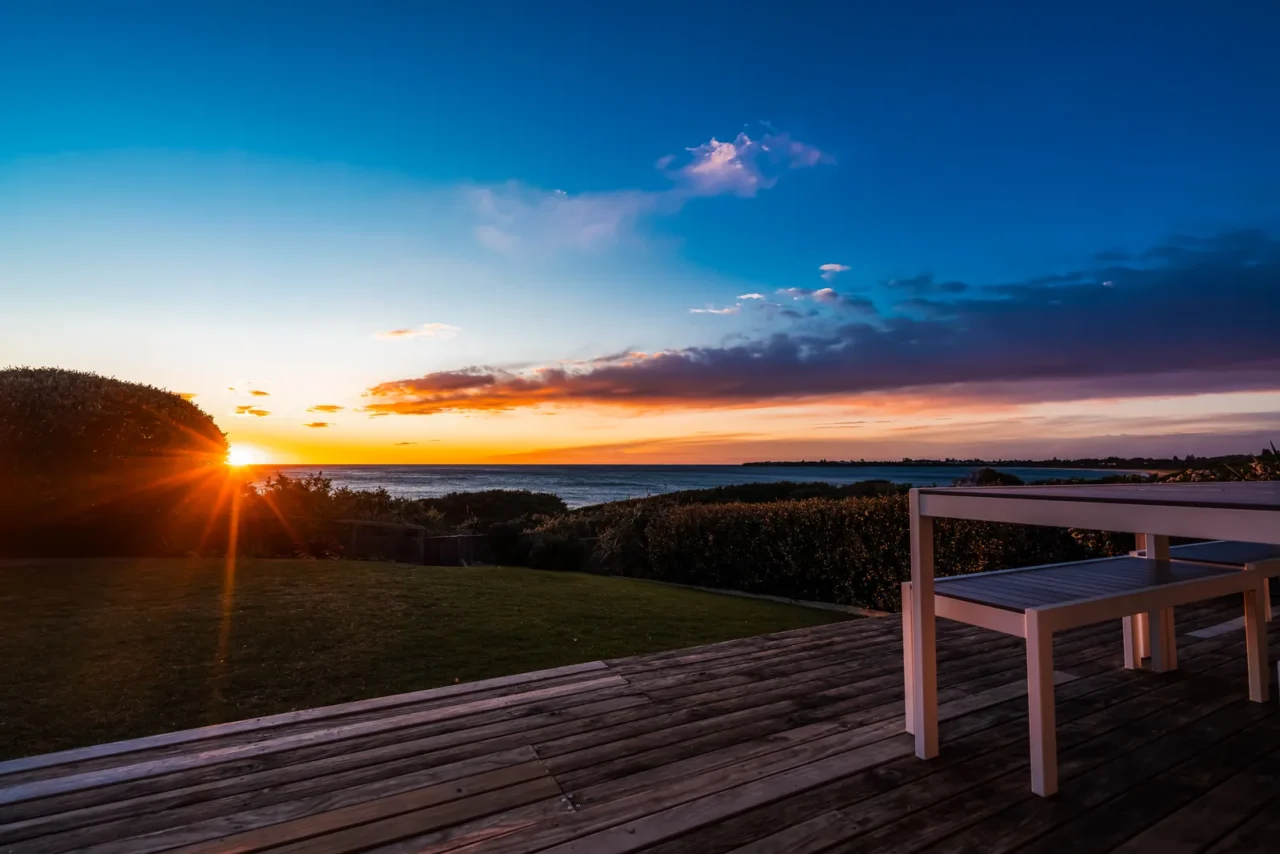 Deck de madeira com vista para o mar ao entardecer, no litoral sul de São Paulo