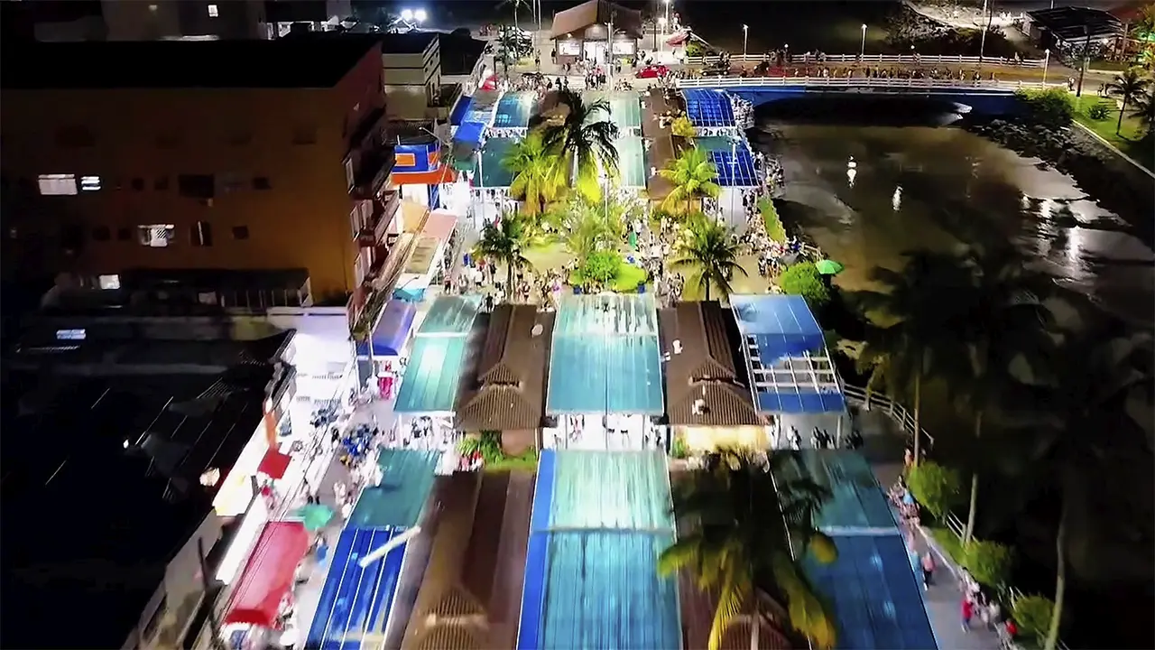 Avenida da praia no Centro de Mongaguá cheia de gente em noite de fim de ano